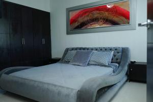 a large bed in a bedroom with a painting on the wall at Apartamento moderno y centrado en Barranquilla in Barranquilla