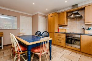 kuchnia z niebieskim stołem i krzesłami w obiekcie The Apartment w mieście Bamburgh