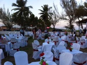 a group of white tables and white chairs and palm trees at Pousada Cataventos in Sirinhaém