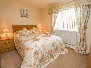 a bedroom with a bed with two towels on it at New Cottage in Wooler