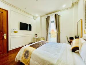 a bedroom with a bed and a tv on the wall at NEW PALACE HOTEL in Quang Ngai
