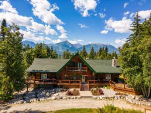 a log home with mountains in the background at Moberly Lodge in Golden