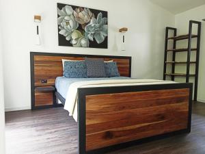 1 dormitorio con 1 cama con cabecero de madera en Chilamate Holiday House, en Puerto Viejo