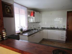 eine Küche mit weißen Schränken, einem Waschbecken und einem Fenster in der Unterkunft Alojamiento La Puntilla Gran casa orilla Lago Rapel piscina ,jardines ,quincho ,terrazas,para 13 in Las Cabras