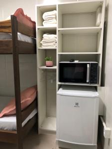 a microwave sitting on top of a refrigerator in a room at Maga hospedagem in Penha