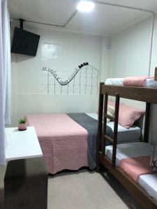 a bedroom with two bunk beds with pink sheets at Maga hospedagem in Penha