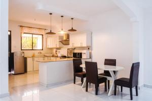 a kitchen and dining room with a table and chairs at Uhai Vacations in Diani Beach