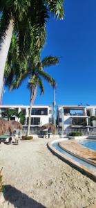 a resort with palm trees and a swimming pool at Apartasol Ciudadela Santafe - Santa Fe de Antioquia in Santa Fe de Antioquia