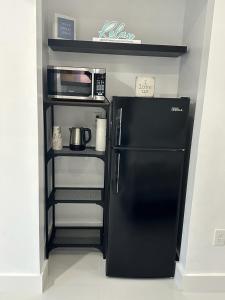 a kitchen with a black refrigerator and a microwave at Casa West Miami in Miami