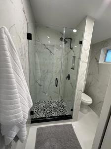 a bathroom with a glass shower with a toilet at Casa West Miami in Miami