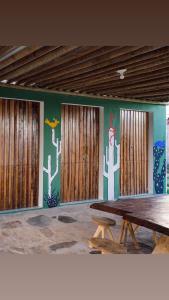 a room with a table and a wall with cactus at Casa Cacto - Ilha do Ferro AL in Pão de Açúcar