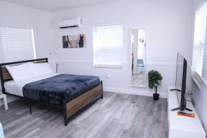 um quarto com uma cama, uma secretária e uma televisão em Douglas rd apartments em Miami