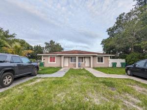 une maison avec deux voitures garées devant elle dans l'établissement MiLuSol, à Miami