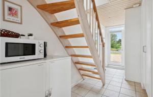 a kitchen with a microwave and a staircase at Stunning Home In Nrre Nebel With Kitchen in Nørre Nebel