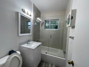 a white bathroom with a sink and a shower at Douglas rd apartments in Miami
