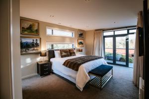 ein Schlafzimmer mit einem Bett und einem großen Fenster in der Unterkunft Mt Gold Retreat - Sleeps 8 - Spa Pool - Tennis Court in Wanaka