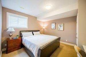 a bedroom with a large bed and a window at Kelowna Spacious 3 Bedroom House in Kelowna