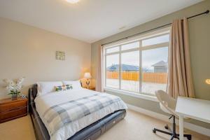 a bedroom with a bed and a window and a desk at Kelowna Spacious 3 Bedroom House in Kelowna