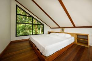 una camera da letto con un grande letto con una grande finestra di The Source Yoga and Nature Sanctuary Koh Phangan a Ko Phangan