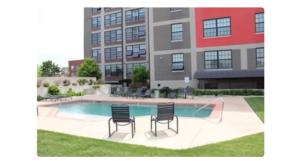 two chairs and a pool in front of a building at Cozy Stylish Downtown Loft in Saint Louis
