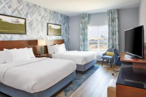 Fairfield Inn and Suites by Marriott Nashville Downtown/The Gulch في ناشفيل: غرفة فندقية بسريرين وتلفزيون بشاشة مسطحة