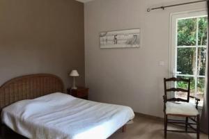 Un dormitorio con una cama y una silla y una ventana. en Nice 90m near the surf beach of Bud, en Longeville-sur-Mer
