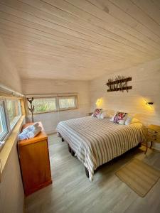 1 dormitorio con 1 cama grande en una habitación en Refugio con calefaccion central y tinaja, en Malalcahuello