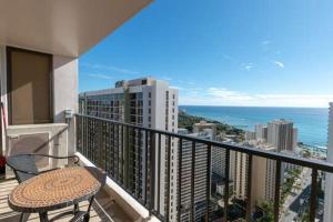 een balkon met een tafel en uitzicht op de oceaan bij 37th Floor Condo with Sweeping Ocean Views & Free parking! condo in Honolulu