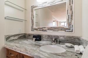 La salle de bains est pourvue d'un lavabo en marbre et d'un miroir. dans l'établissement Tower 1 Suite 2705 - QQS, à Honolulu 18 autres photos