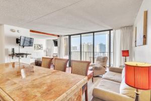 ein Wohnzimmer mit einem Tisch und einem Sofa in der Unterkunft 19th Floor Condo with Lanai & Sea Views - FREE Parking! home in Honolulu