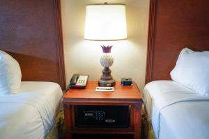 a lamp on a table between two beds in a hotel room at Rosen Inn Lake Buena Vista in Orlando