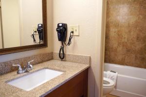 a bathroom with a sink and a phone on the wall at Rosen Inn Lake Buena Vista in Orlando