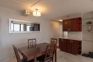 uma cozinha e sala de jantar com mesa e cadeiras em Newly Remodeled Corner Unit at the Waikiki Banyan with Diamond Head Views condo em Honolulu