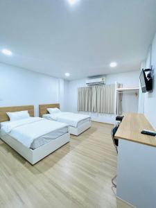 2 camas en una habitación con escritorio y ordenador en PD Apartment Inn, en Ban Pra Dok
