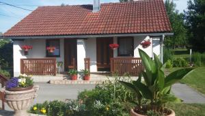 une petite maison blanche avec un toit rouge dans l'établissement Guest House Family Dukić, à Rakovica