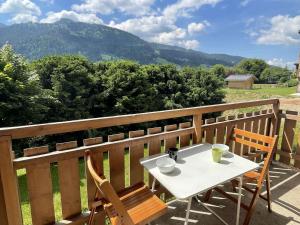 een witte tafel en stoelen op een balkon met uitzicht op de bergen bij Appartement Praz-sur-Arly, 1 pièce, 5 personnes - FR-1-603-79 in Praz-sur-Arly