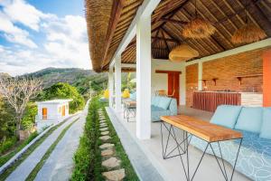 an outdoor patio with blue chairs and a table at Lombok Khophilauvillas in Kuta Lombok
