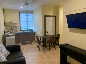 a living room with a table and a kitchen at Samoa Business Apartments 2 in Apia