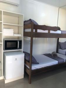 two bunk beds in a room with a microwave at Maga hospedagem in Penha +37 photos