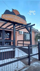 a sign in front of a building with a fence at Pousada Encanto dos Cânions in Cambara do Sul