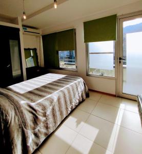 1 dormitorio con 1 cama y 2 ventanas en SMA AltoRoca7, en San Martín de los Andes