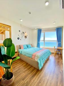 ein Schlafzimmer mit einem Bett und einem großen Fenster in der Unterkunft Nice Oasky Sea View Apartment in Vung Tau in Vũng Tàu
