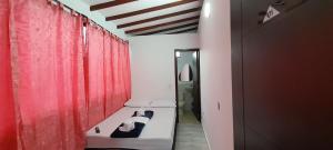 Habitación pequeña con cortinas rojas y cama en Hotel Caldas Real, en Caldas