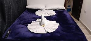 a bed with two white flowers on it at Hotel Caldas Real in Caldas