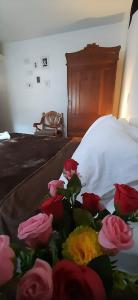 um ramo de rosas sentado numa cama em Villa del Prado em Medellín