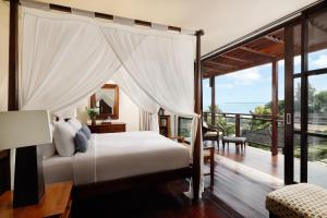 1 dormitorio con 1 cama y balcón en Villa Jamalu by Nakula, en Jimbaran