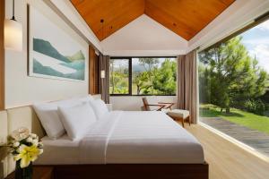 a bedroom with a bed and a large window at Dusun Bedugul Asri in Bedugul