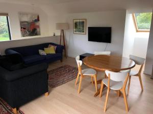 een woonkamer met een tafel en een bank bij Ryland Estate Guest Apartment in Kaituna