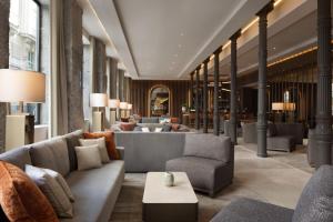 Eine Hotellobby mit Sofas und Tischen in der Unterkunft JW Marriott Hotel Madrid in Madrid