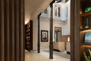 un corridoio con colonne e librerie in un edificio di JW Marriott Hotel Madrid a Madrid